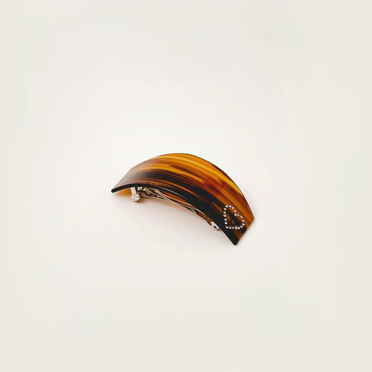 Front view of Tortoiseshell curved hairpin with a rhinestone heart design.
