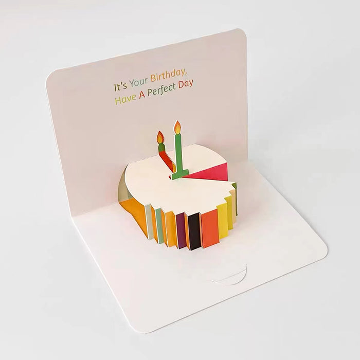 Front view of White paper pop-up birthday card with a 3D colorful cake and two candles.