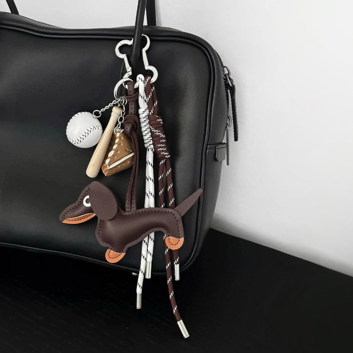 Leather dachshund charm attached to a minimalist black tote bag; perfect pet-centric personalization for daily use.