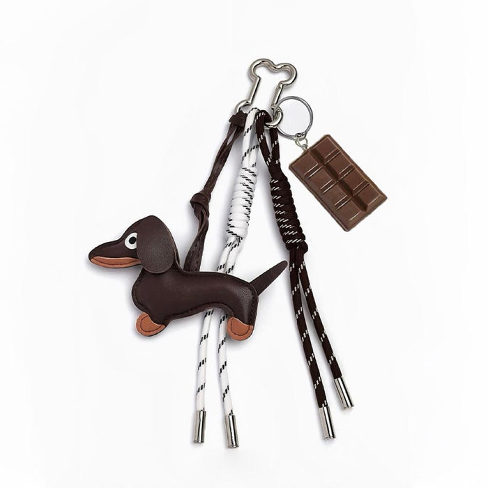 Close-up of the dachshund bag charm with braided ropes and chocolate element ; showcasing the bone-shaped alloy clip.