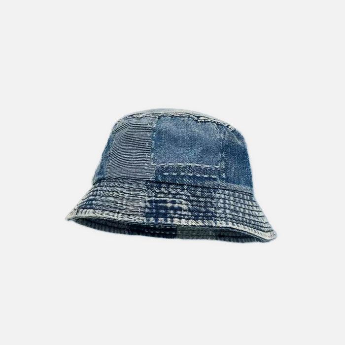 Multi-wash blue denim patchwork bucket hat featuring visible stitching and an artisanal retro look.