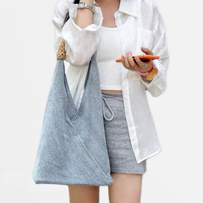 Model carrying a light blue Denim Shoulder Bag handheld, easy for commuting and weekends.