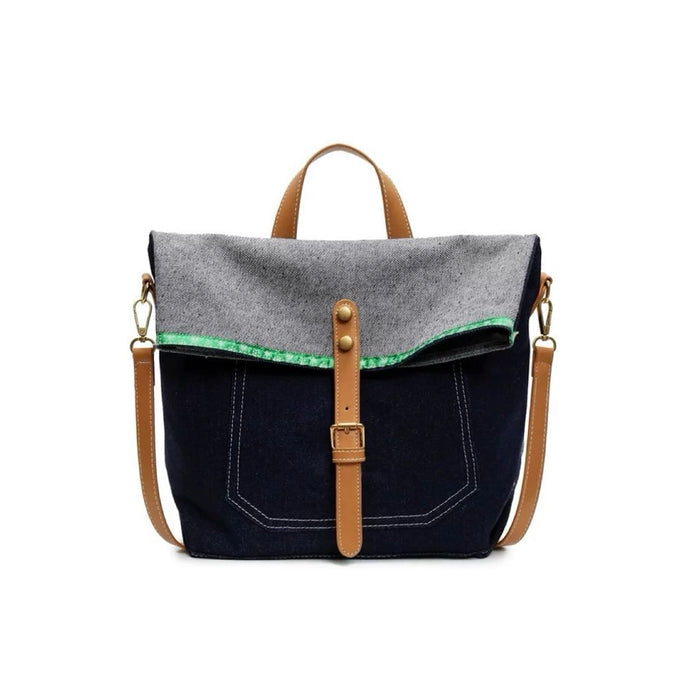 Front view of Denim trimmed messenger bag with gray flap, brown straps, magnetic closure, and green accent.