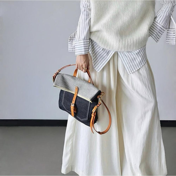 Model carrying a  Denim Trimmed Messenger Bag handheld, great for daily carry and travel.