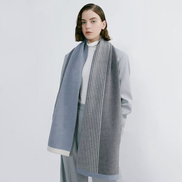 Model wearing a striped scarf in gray and blue , great for office layering and commuting.