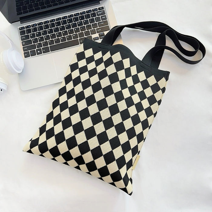 Angled view of Black and beige diamond knitted polyester tote bag with black straps.