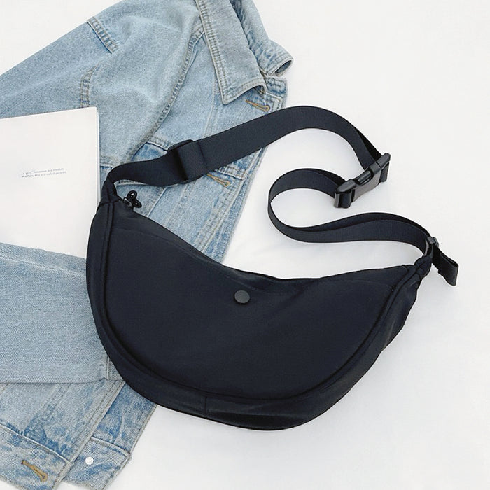 Black crescent crossbody bag showing the adjustable wide shoulder strap for ergonomic and comfortable daily carry.