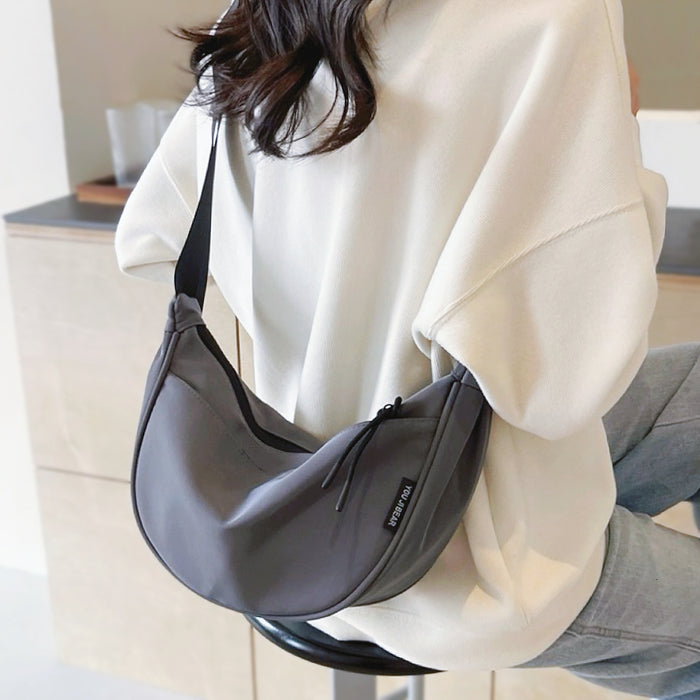 Close-up of model wearing the grey crescent bag; highlight of the high-density nylon texture and adjustable strap length.