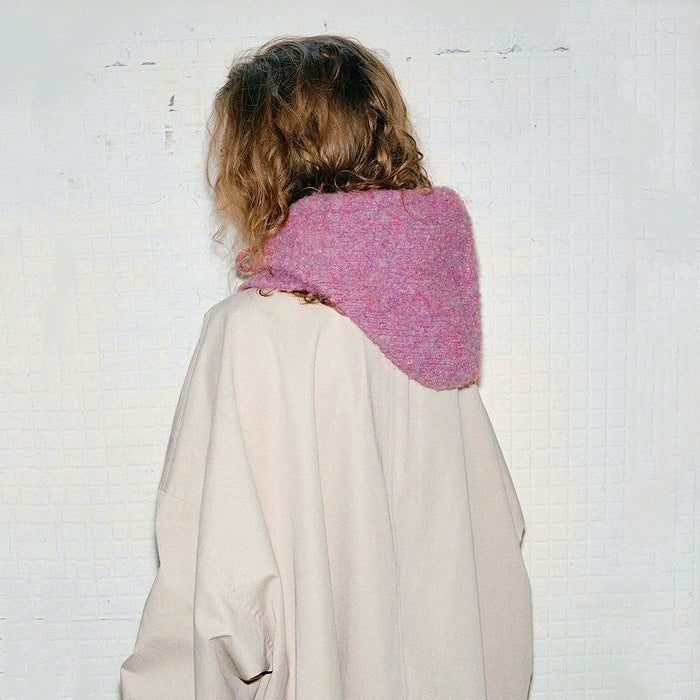 Back view of a mauve pink knitted balaclava hat, showing the seamless hood design and drape.