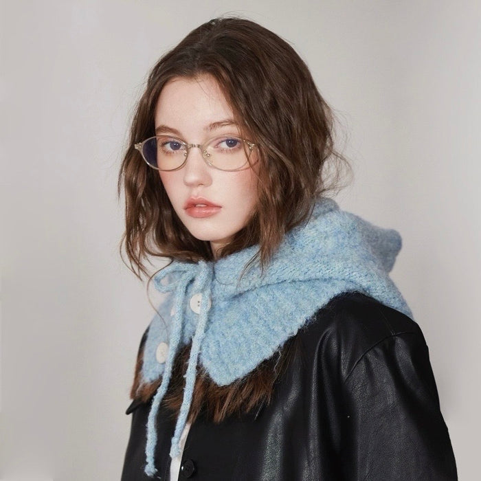 Side profile of the blue knitted balaclava hat styled with a black leather jacket for a chic winter look.