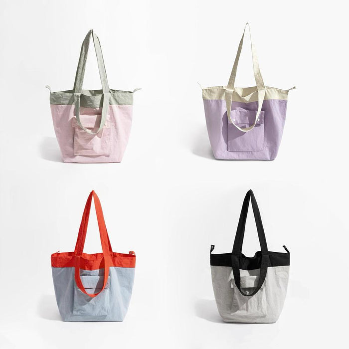 Folded view of Four duotone foldable nylon tote bags in pink/sage, lavender/cream, blue/orange, and black/grey nylon.