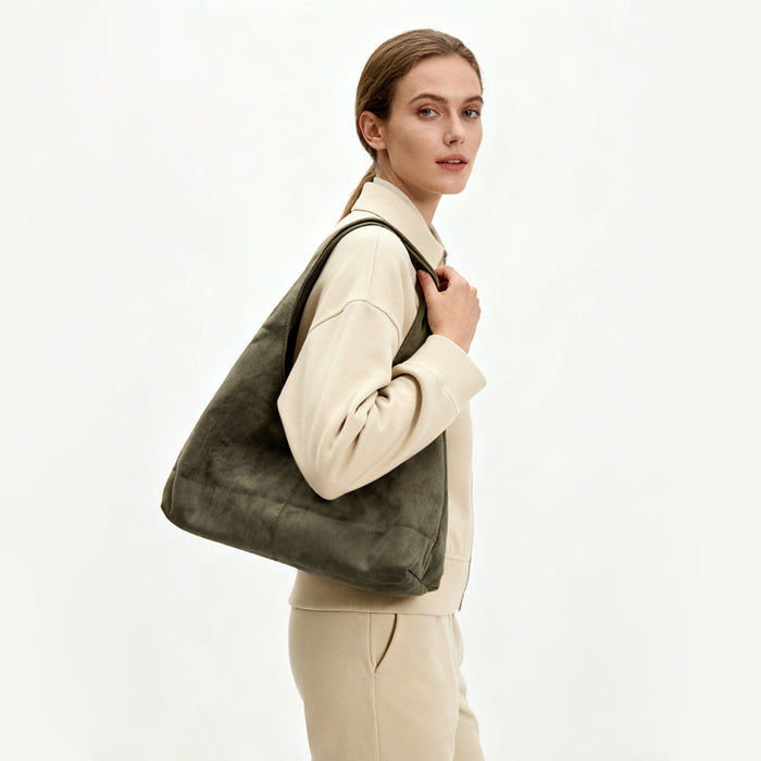 Olive green ease suede hobo bag styled for a casual outdoor look.