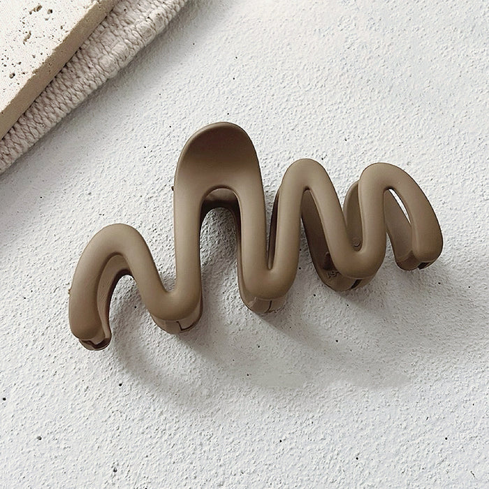 Close-up of Elegant Wave Hair Claw in light brown, easy for workdays and special occasions.