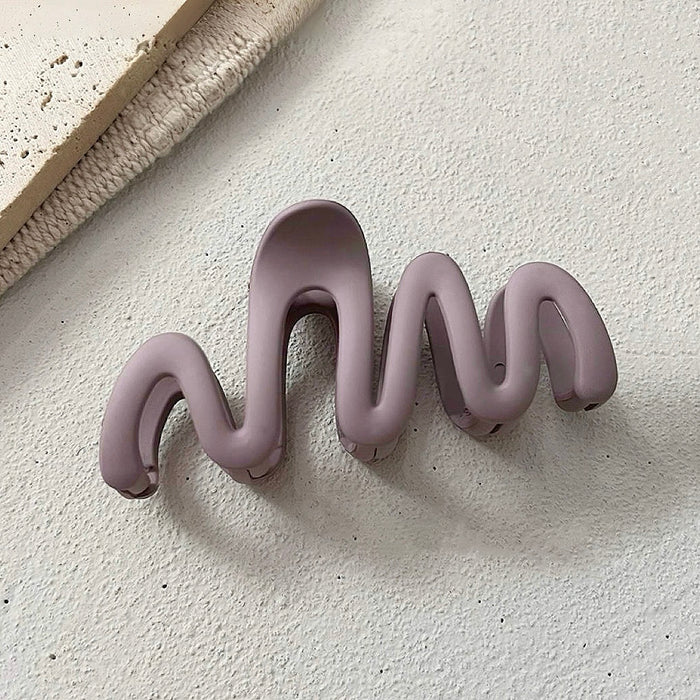Angled view of Elegant Wave Hair Claw  in purple, great for everyday styling and gifting.