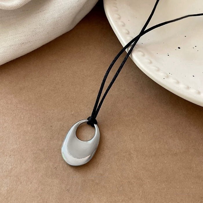 Folded view of Eon Circle Pendant Necklace in silver, ideal for date nights.