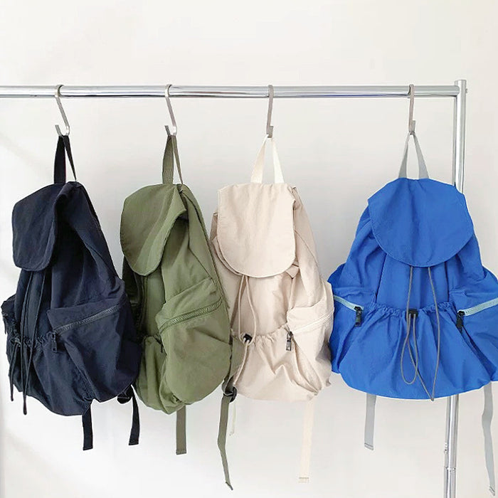 Group of four ultralight backpacks in black, olive green, beige, and blue; best affordable minimalist gear under $50.