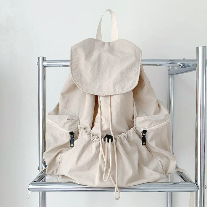 Front view of beige ultralight backpack; soft neutral tone suited for minimalist fashion and summer organization.