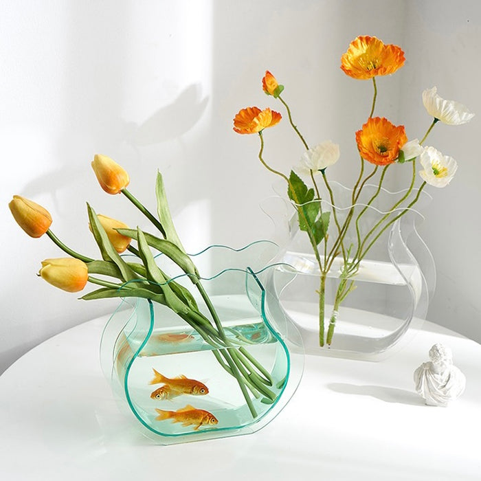 Angled view of two Fishtail Flower Vases, one is clear and one is green.