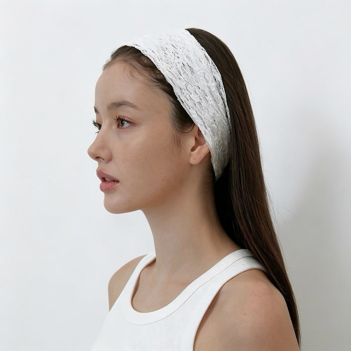 Side profile of a model showing the comfortable fit of the white lace hairband tucked behind the ear.