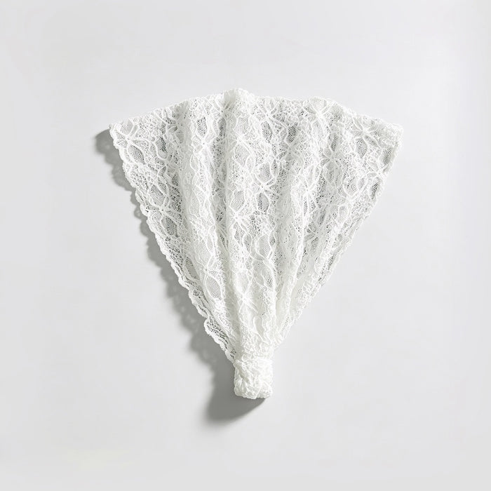 Studio flat lay of the white floral lace headband unfolded into a fan shape displaying the elastic bottom band.