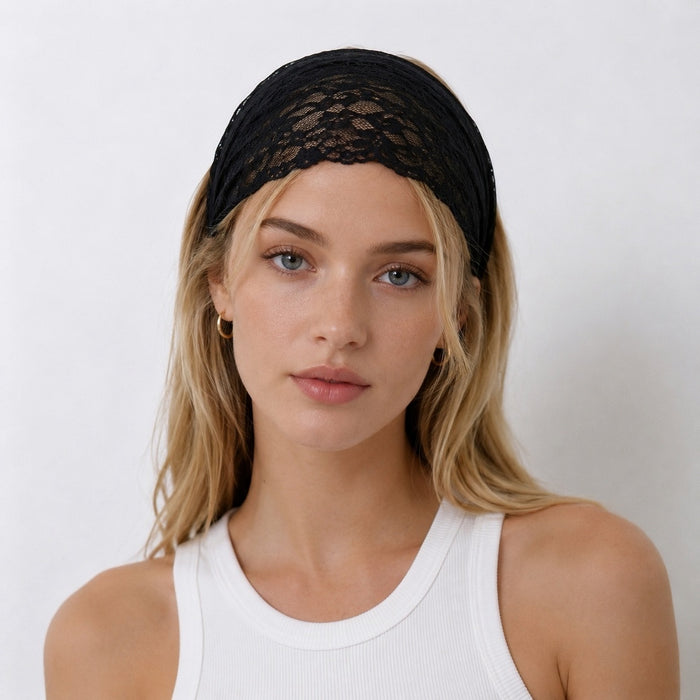 Front view of a blonde model styling the black floral lace headband as a wide hair wrap.