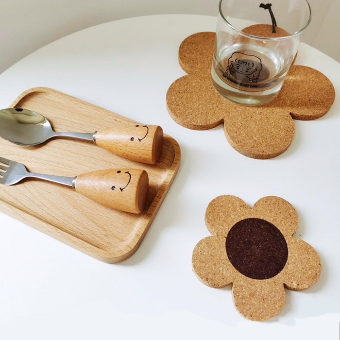 Angled view of two Flower Cork Coaster/Hot Pads on a white table, with a cup on one coster.