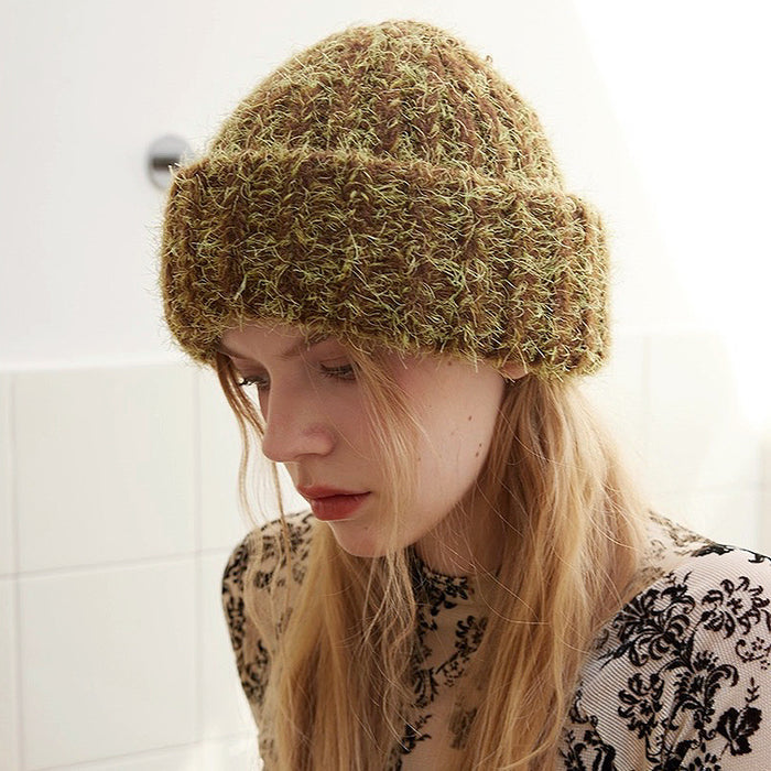 Woman wearing fluffy knitted thick beanie in brown and lime green, crafted for maximum thermal insulation.