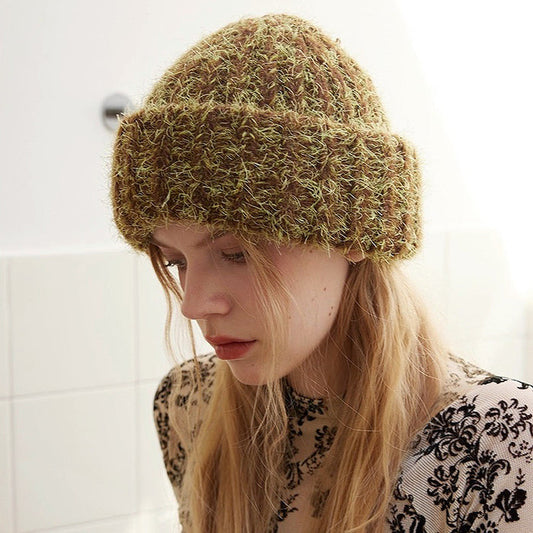Woman wearing fluffy knitted thick beanie in brown and lime green, crafted for maximum thermal insulation.
