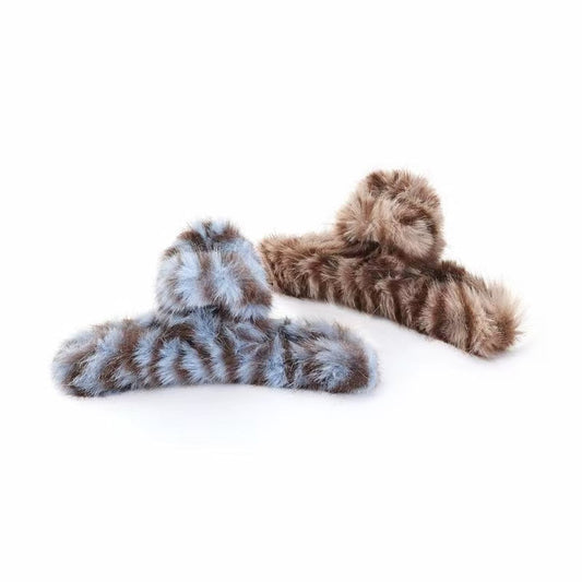 Front view of Two fluffy striped hair claws, one blue and one brown.