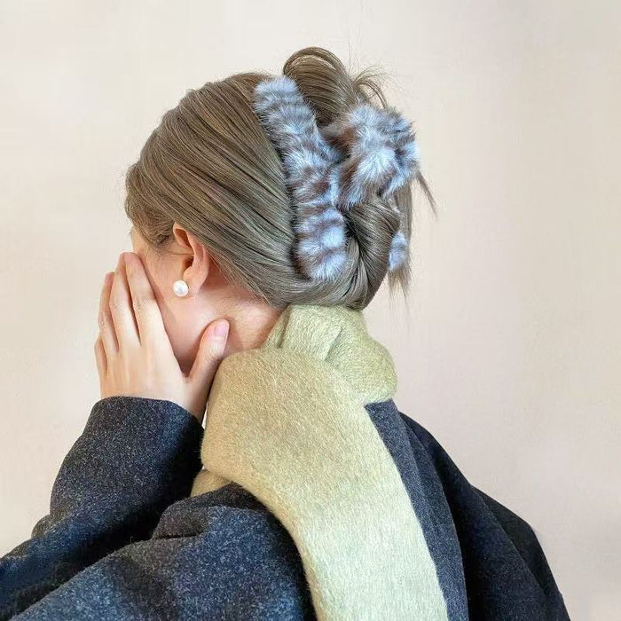 Model wearing a blue  fluffy striped hair claw, great for date nights and events.