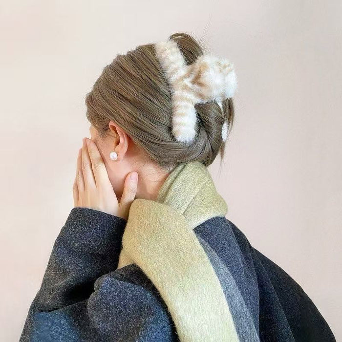 Model wearing a beige fluffy striped hair claw, ideal for everyday outfits and office looks.