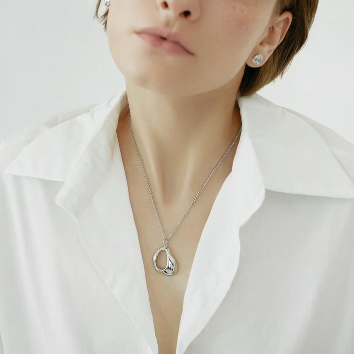 Close-up of silver Fluid Shaped Pendant Necklace worn on woman, ideal for date nights.