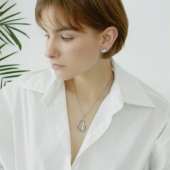 Model wearing a silver Fluid Shaped Pendant Necklace, easy for gifting and photo-ready styling.