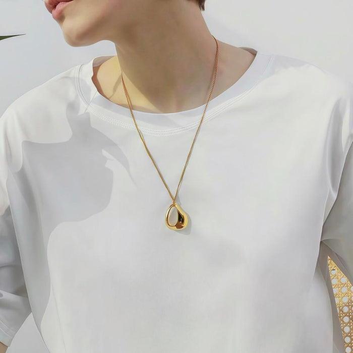 Model wearing Fluid Shaped Pendant Necklace in Gold, great for everyday outfits.