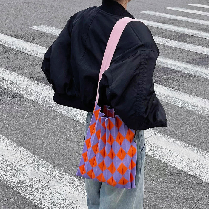 Back view of a model styling a purple and orange argyle tote bag.