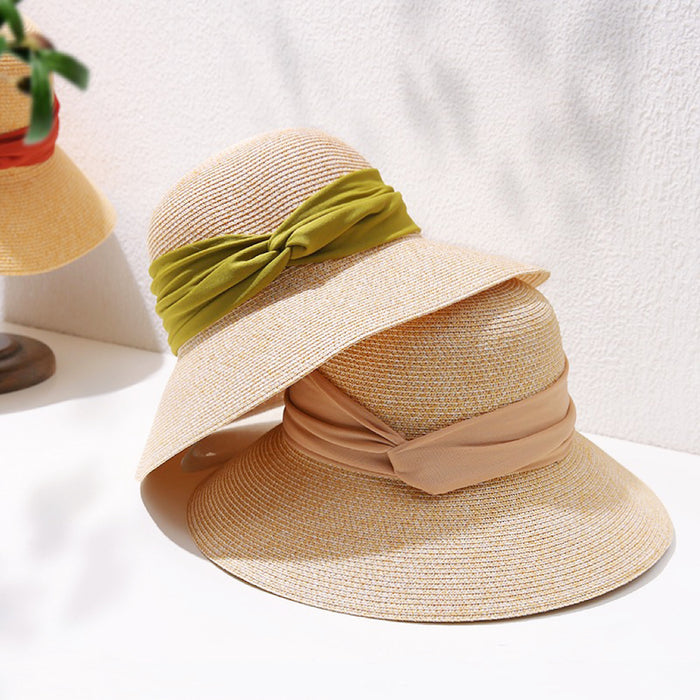 Foldable straw sun hats with wide brims and elegant ribbon bands in olive green and classic beige.
