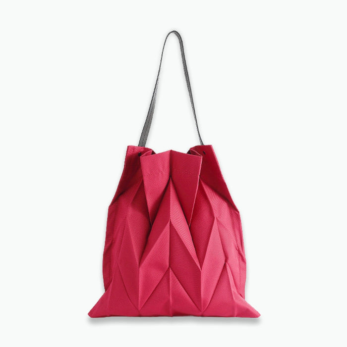 Front view of  vibrant red pleated shopper bag; bold statement accessory suited for festive events and holiday shopping.