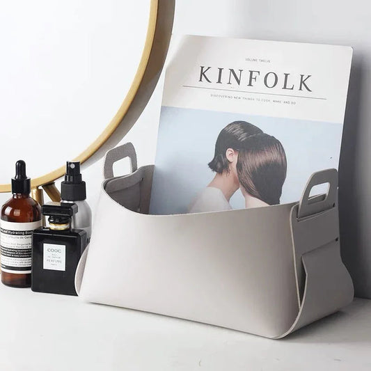 Minimalist grey PU leather storage basket with perfumes; waterproof surface ideal for bathroom or vanity organization.