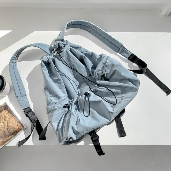 Blue waterproof polyester backpack with drawstring closure and functional side zip pockets.