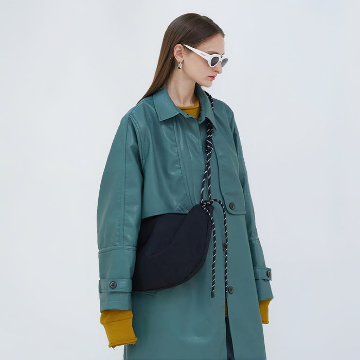 Side view of a black nylon hobo bag worn as an crossbody bag, perfect for daily commute and office chic.