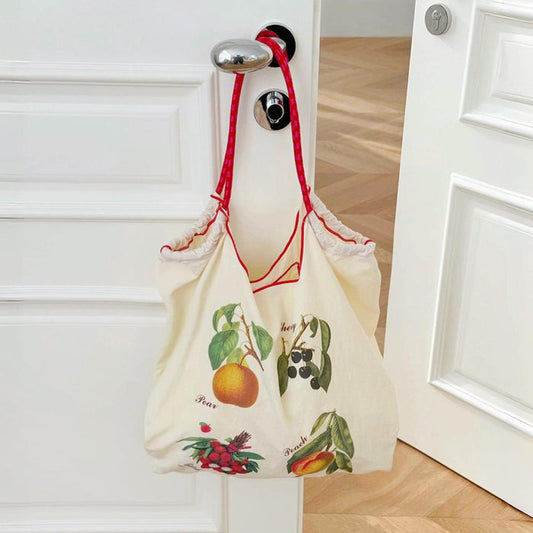 Front view of Polyester Fruit Delight Tote Bag with colorful fruit illustrations and red grab straps.