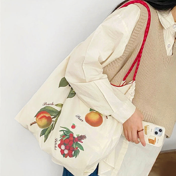 Close-up of Fruit Delight Tote Bag with colorful peach, pear, and lychee fruit print.