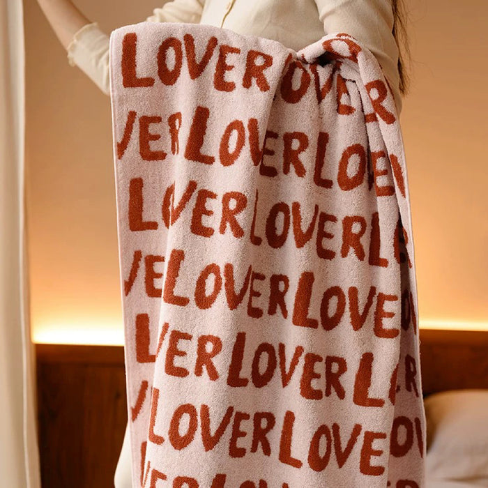 Model holding a cotton bath towel with repeating LOVER text.