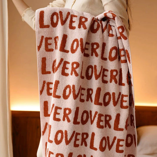Model holding a cotton bath towel with repeating LOVER text.