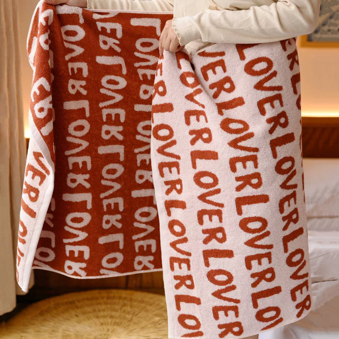 Close-up do full of love bath towel with repeating red lover text.
