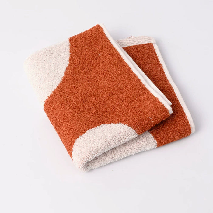 Close-up of Folded face towel with heart pattern on clean background.