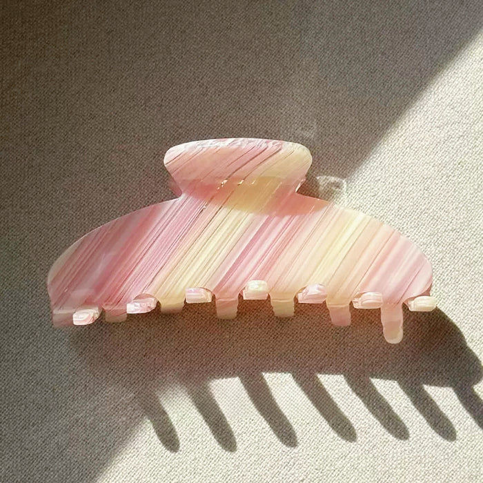Angled view of Gentle Curve Hair Claw in cream pink stripe pattern, ideal for quick updos and ponytails.