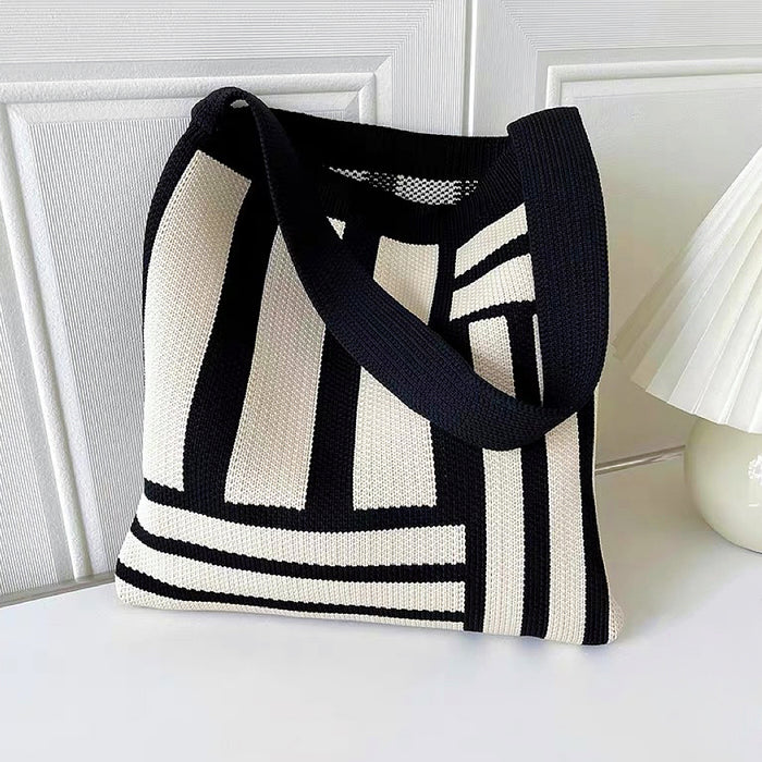 Close-up of Black and white geometric line knitted  bag with elastic shoulder strap and open top .