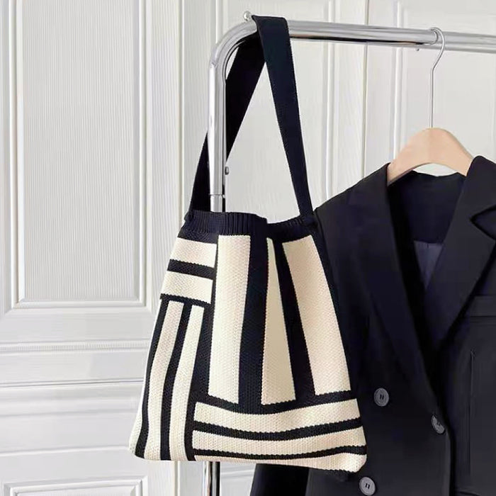 Front view of black Geometric Line Knitted Bag hanging on a hanger , great for everyday carry and travel.