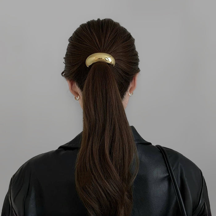 Model wearing a large Gleaming Curve Hair Cuff in gold, easy for workdays and special occasions.